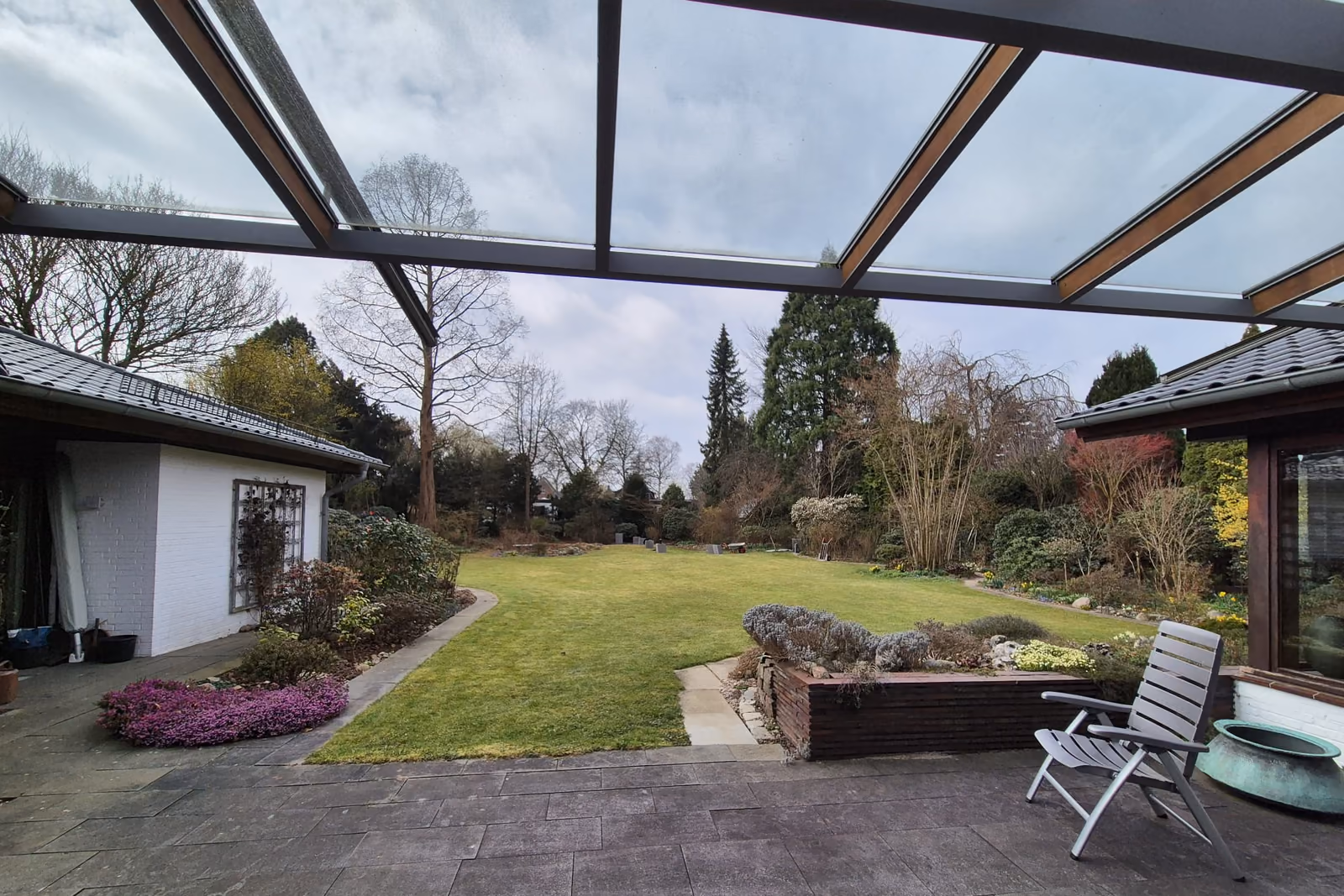 Blick vom überdachten Terrassenbereich über den angelegten Garten