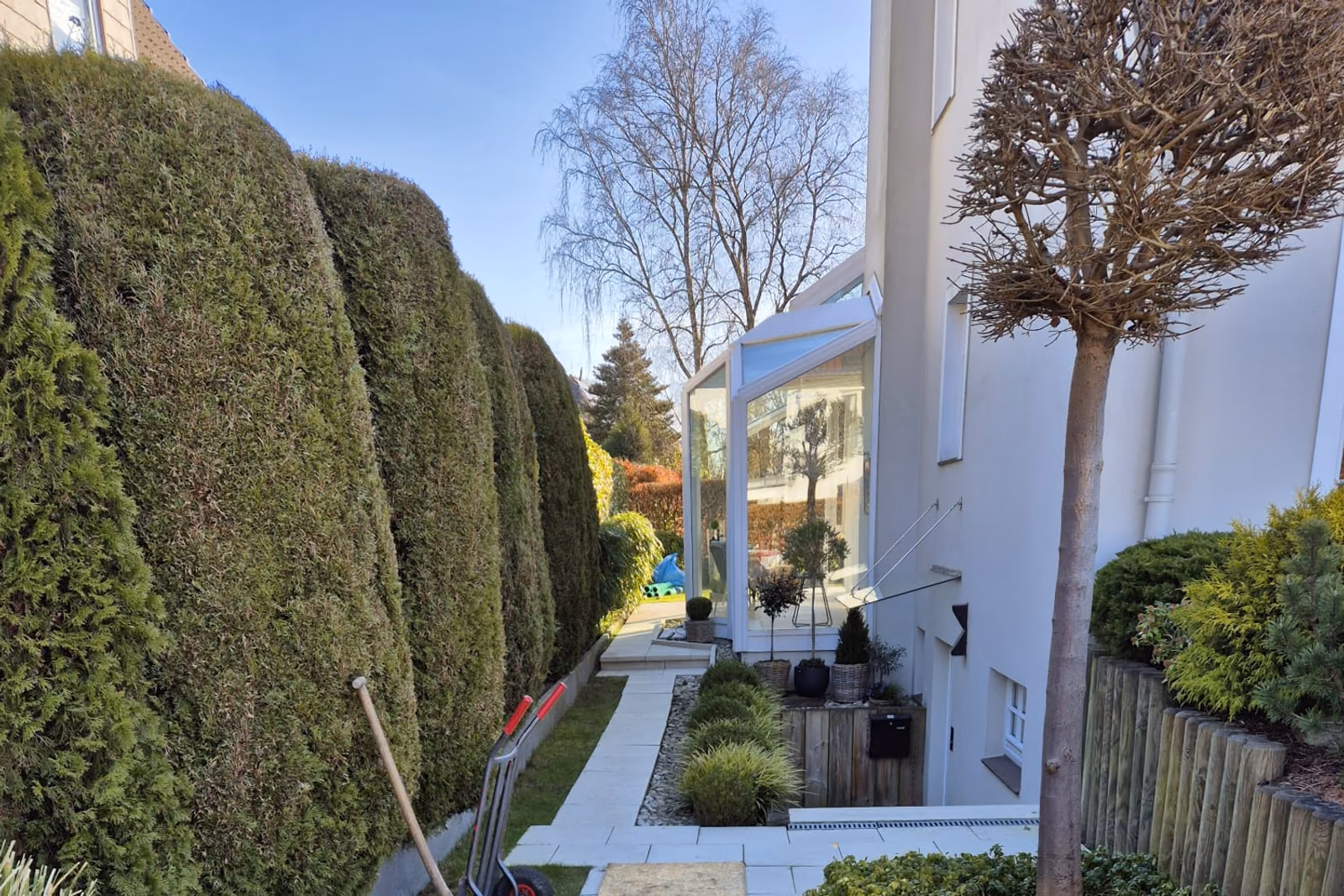 Der Weg zwischen Thujahecke und Wintergarten, mit Entwässerungsrinne am Übergang